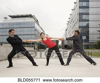 Stock Photography - multi-ethnic businessmen 
having tug of 
war with woman. 
fotosearch - search 
stock photos, 
pictures, images, 
and photo clipart