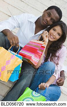 Stock Photography - multi-ethnic couple 
holding shopping 
bags. fotosearch 
- search stock 
photos, pictures, 
images, and photo 
clipart