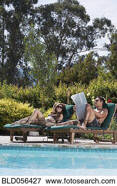 Picture - multi-ethnic couple 
relaxing next 
to swimming pool. 
fotosearch - search 
stock photos, 
pictures, images, 
and photo clipart
