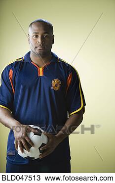 Stock Photo - african american 
man holding soccer 
ball. fotosearch 
- search stock 
photos, pictures, 
images, and photo 
clipart