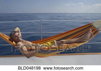 Stock Photo - man laying in 
hammock on boat. 
fotosearch - search 
stock photos, 
pictures, images, 
and photo clipart