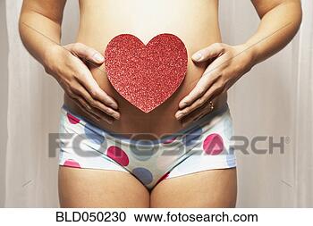 Stock Photography - pregnant mixed 
race woman with 
cut-out heart 
on belly. fotosearch 
- search stock 
photos, pictures, 
images, and photo 
clipart