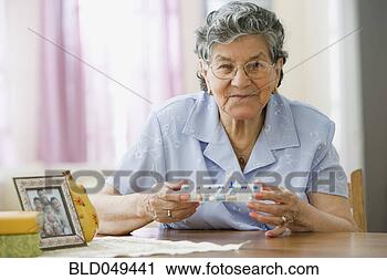Stock Photography - senior hispanic 
woman holding 
pill organizer. 
fotosearch - search 
stock photos, 
pictures, images, 
and photo clipart