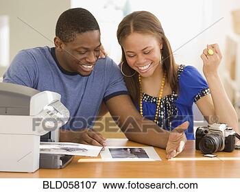 Picture - african couple 
printing out photographs. 
fotosearch - search 
stock photos, 
pictures, images, 
and photo clipart