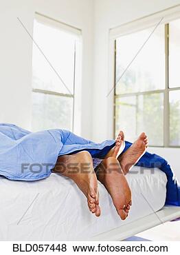 Stock Photo - african couple’s 
feet in bed. fotosearch 
- search stock 
photos, pictures, 
images, and photo 
clipart