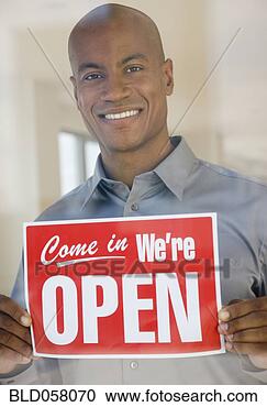 Stock Photography - african man holding 
open sign. fotosearch 
- search stock 
photos, pictures, 
images, and photo 
clipart