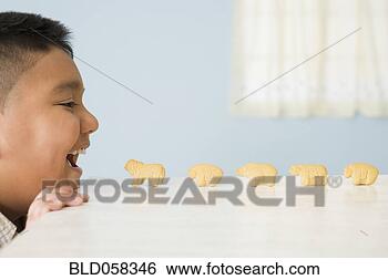 Stock Photo - animal crackers 
lined up in front 
of hispanic boy’s 
mouth. fotosearch 
- search stock 
photos, pictures, 
images, and photo 
clipart