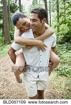 Stock Photograph - hispanic man giving 
girlfriend piggyback 
ride. fotosearch 
- search stock 
photos, pictures, 
images, and photo 
clipart