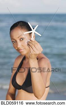 Stock Photo - hispanic woman 
holding starfish. 
fotosearch - search 
stock photos, 
pictures, images, 
and photo clipart