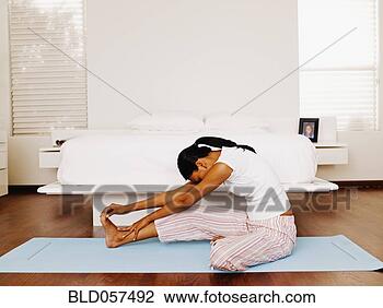 Stock Photo - indian woman stretching 
on yoga mat. fotosearch 
- search stock 
photos, pictures, 
images, and photo 
clipart