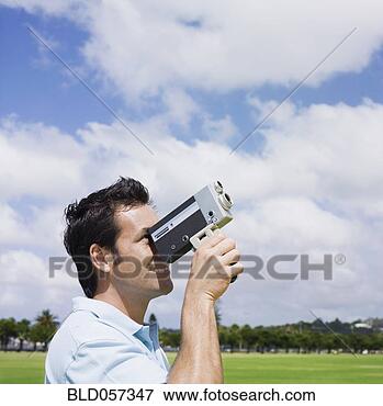 Picture - mixed race man 
looking through 
old fashioned 
film camera. fotosearch 
- search stock 
photos, pictures, 
images, and photo 
clipart
