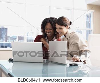 Stock Photography - multi-ethnic businesswomen 
looking at laptops. 
fotosearch - search 
stock photos, 
pictures, images, 
and photo clipart