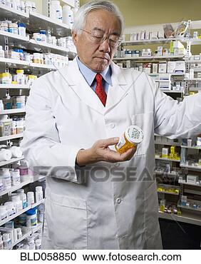 Stock Photography - senior asian pharmacist 
reading medication. 
fotosearch - search 
stock photos, 
pictures, images, 
and photo clipart