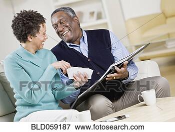 Picture - african couple 
looking at photo 
album. fotosearch 
- search stock 
photos, pictures, 
images, and photo 
clipart
