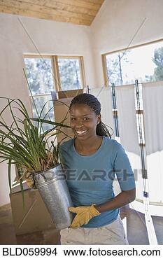 Stock Photo - african woman 
carrying plant 
in new home. fotosearch 
- search stock 
photos, pictures, 
images, and photo 
clipart