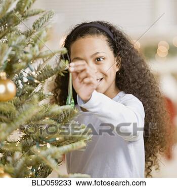 Stock Photo - mixed race girl 
hanging ornament 
on christmas tree. 
fotosearch - search 
stock photos, 
pictures, images, 
and photo clipart