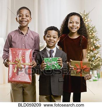 Stock Photograph - mixed race siblings 
holding christmas 
gifts. fotosearch 
- search stock 
photos, pictures, 
images, and photo 
clipart