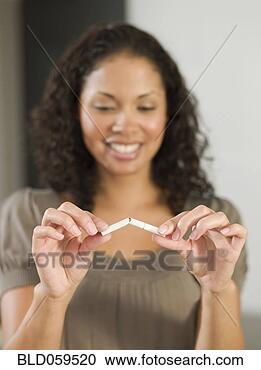Stock Photography - mixed race woman 
breaking cigarette. 
fotosearch - search 
stock photos, 
pictures, images, 
and photo clipart