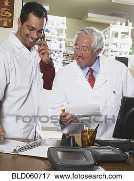 Picture - multi-ethnic pharmacists 
looking at paperwork. 
fotosearch - search 
stock photos, 
pictures, images, 
and photo clipart