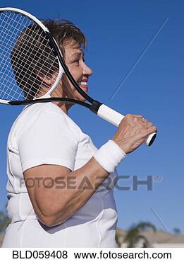 Stock Photo - senior hispanic 
woman holding 
tennis racket. 
fotosearch - search 
stock photos, 
pictures, images, 
and photo clipart