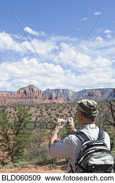 Stock Photograph - senior man taking 
photograph of 
desert landscape. 
fotosearch - search 
stock photos, 
pictures, images, 
and photo clipart