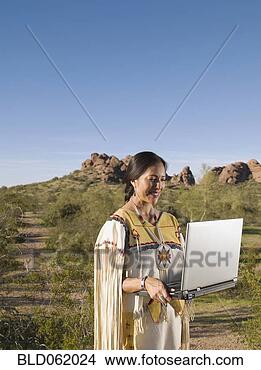 Stock Photo - native american 
woman in traditional 
clothing with 
laptop outdoors. 
fotosearch - search 
stock photos, 
pictures, images, 
and photo clipart