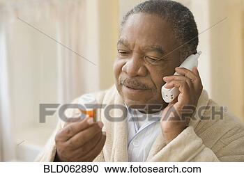 Stock Photography - african man holding 
prescription bottle 
and talking on 
phone. fotosearch 
- search stock 
photos, pictures, 
images, and photo 
clipart