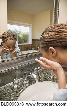 Stock Photo - african woman 
washing face at 
bathroom sink. 
fotosearch - search 
stock photos, 
pictures, images, 
and photo clipart
