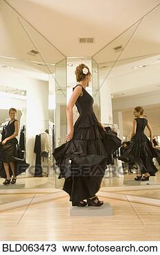 Stock Photo - mixed race woman 
trying on flamenco 
dress in shop. 
fotosearch - search 
stock photos, 
pictures, images, 
and photo clipart
