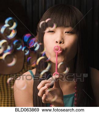 asian-woman-blowing_~BLD063869.jpg