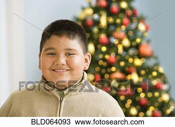 Stock Photo - hispanic boy smiling 
near christmas 
tree. fotosearch 
- search stock 
photos, pictures, 
images, and photo 
clipart