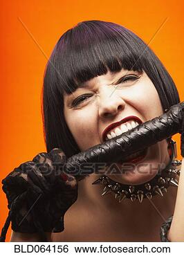 Stock Photo - mixed race dominatrix 
biting whip handle. 
fotosearch - search 
stock photos, 
pictures, images, 
and photo clipart