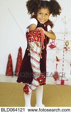Stock Photography - mixed race girl 
reaching into 
christmas stocking. 
fotosearch - search 
stock photos, 
pictures, images, 
and photo clipart