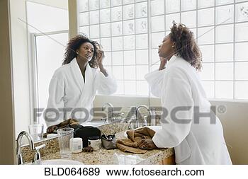 Stock Photograph - african woman 
putting on makeup 
in bathroom. fotosearch 
- search stock 
photos, pictures, 
images, and photo 
clipart