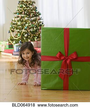 Stock Photo - curious young 
girl near large 
christmas gift. 
fotosearch - search 
stock photos, 
pictures, images, 
and photo clipart