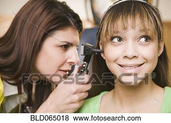 Stock Photo - mixed race doctor 
examining teenage 
girl’s ears. fotosearch 
- search stock 
photos, pictures, 
images, and photo 
clipart