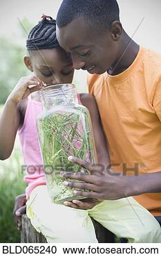Stock Photography - african brother 
and sister peering 
into insect jar. 
fotosearch - search 
stock photos, 
pictures, images, 
and photo clipart