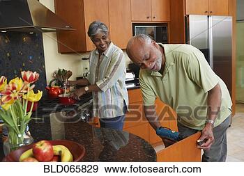 Stock Photograph - african man fixing 
kitchen cabinet 
for wife. fotosearch 
- search stock 
photos, pictures, 
images, and photo 
clipart