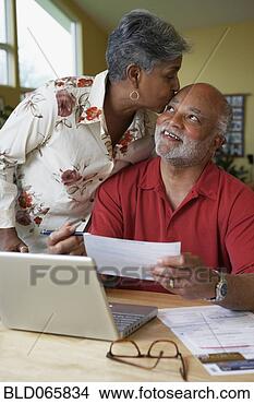 Stock Photo - african woman 
kissing husband 
as he pays bills. 
fotosearch - search 
stock photos, 
pictures, images, 
and photo clipart