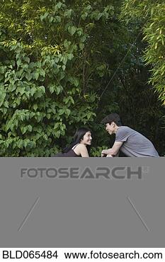 Stock Photo - asian woman leaning 
on fence talking 
to boyfriend. 
fotosearch - search 
stock photos, 
pictures, images, 
and photo clipart