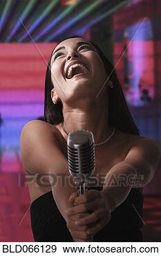 Stock Photograph - glamorous mixed 
race woman singing 
into old-fashioned 
microphone. fotosearch 
- search stock 
photos, pictures, 
images, and photo 
clipart