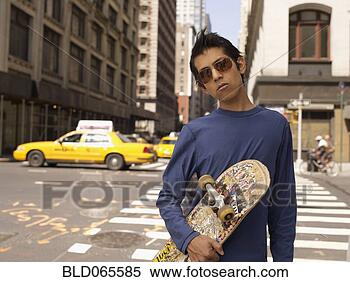 Stock Image - indian man on 
city street holding 
skateboard. fotosearch 
- search stock 
photos, pictures, 
images, and photo 
clipart