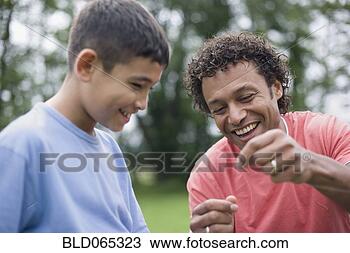 Stock Photo - mixed race father 
helping son with 
fishing line. 
fotosearch - search 
stock photos, 
pictures, images, 
and photo clipart