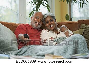 Stock Photograph - senior african 
couple watching 
television. fotosearch 
- search stock 
photos, pictures, 
images, and photo 
clipart