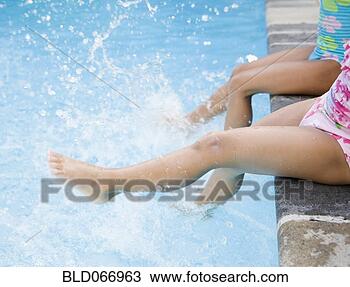 Stock Photo - hispanic girls 
splashing water 
in swimming pool. 
fotosearch - search 
stock photos, 
pictures, images, 
and photo clipart