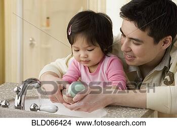 Stock Photo - mixed race father 
helping daughter 
wash her hands. 
fotosearch - search 
stock photos, 
pictures, images, 
and photo clipart