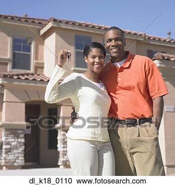 Stock Photography - portrait of a 
mid adult couple 
standing in front 
of a house. fotosearch 
- search stock 
photos, pictures, 
images, and photo 
clipart