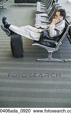 Stock Photography - side profile of 
a businessman 
talking on a mobile 
phone in an airport. 
fotosearch - search 
stock photos, 
pictures, images, 
and photo clipart