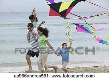 Stock Photography - young couple and 
their children 
running on the 
beach with kites. 
fotosearch - search 
stock photos, 
pictures, images, 
and photo clipart