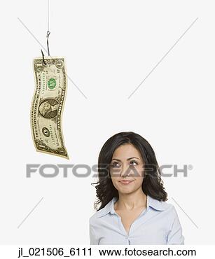 Stock Photography - studio shot of  woman looking  at dollar bill  on fishhook. fotosearch  - search stock  photos, pictures,  images, and photo  clipart